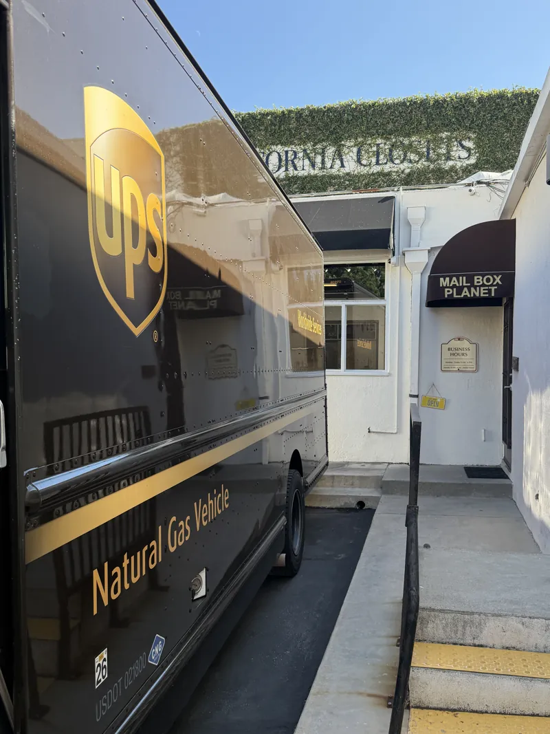 Mailbox Planet’s rear entrance with store signage, viewed during a UPS pickup